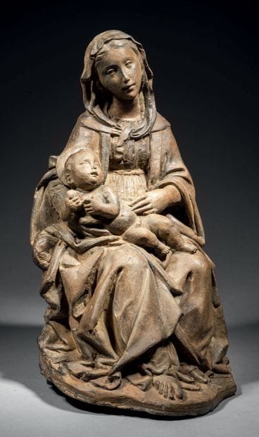 Terracotta Virgin and Child. Mary is seated,...
