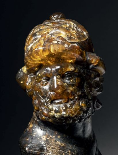 Large amber bust carved in the round representing...