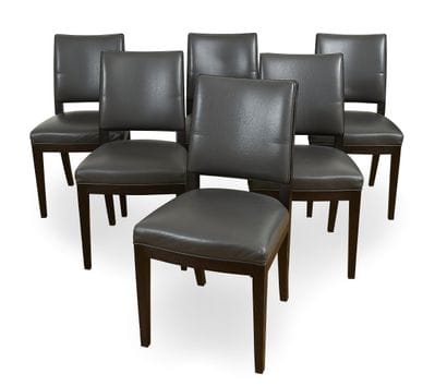 Suite of six stained wood chairs resting...