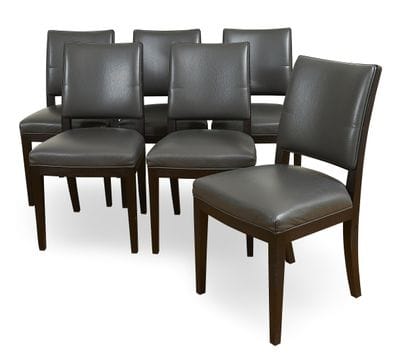 Suite of six stained wood chairs resting...