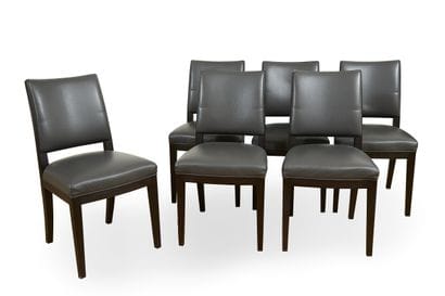 Suite of six stained wood chairs resting...