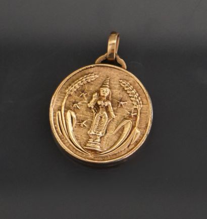 Un médaillon pendentif en métal doré représentant...