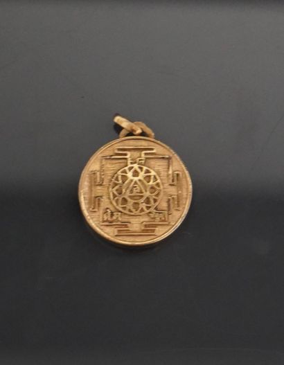 Un médaillon pendentif en métal doré représentant...