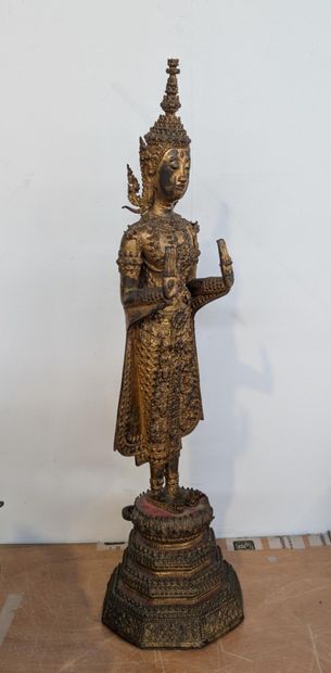 Standing Buddha in gilded bronze in the fearlessness...