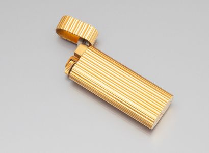 Briquet CARTIER en métal doré rainuré, signé...