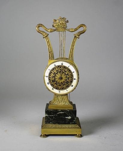 Pendulette en bronze doré surmontée d'une...