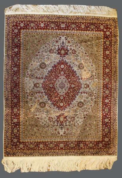 Tapis en soie à décor de rinceaux fleuris...