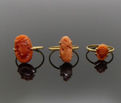 TROIS BAGUES en or, le chaton en corail sculpté...