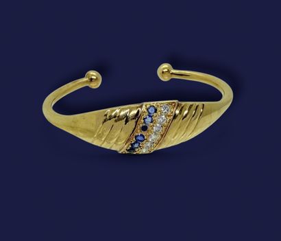 BRACELET rigide en or jaune 750 mil. orné...