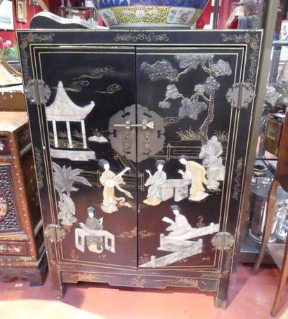 Un petit meuble en bois laqué ouvrant par...