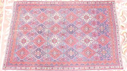 Un TAPIS fond rouge à motifs de losanges....