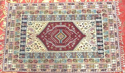TAPIS à motif floral stylisé, franges nouées...