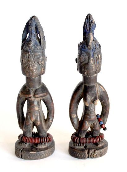 Paire d'IBEDJI en bois sculpté patiné. (Manques)....