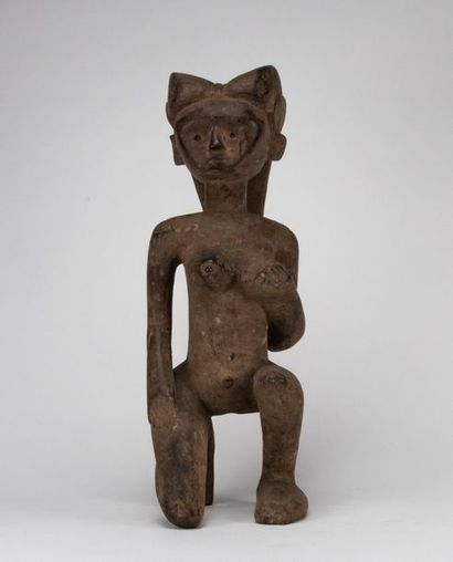 Kneeling woman holding her breast, carved...