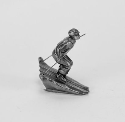 Skier, metal subject. H: 9, D: 8 cm. (a bent...