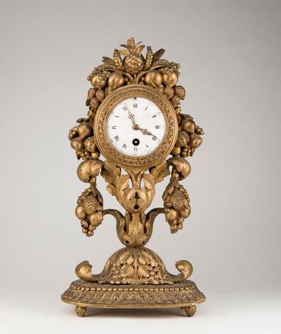 Pendule en bois sculpté et doré à décor de...