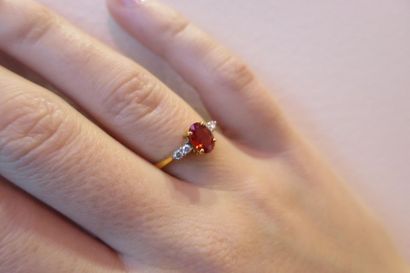 Modern ring with an oval-shaped orange sapphire...
