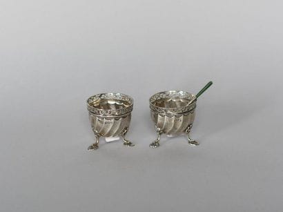 Pair of silver tripod salt shakers, the neck...