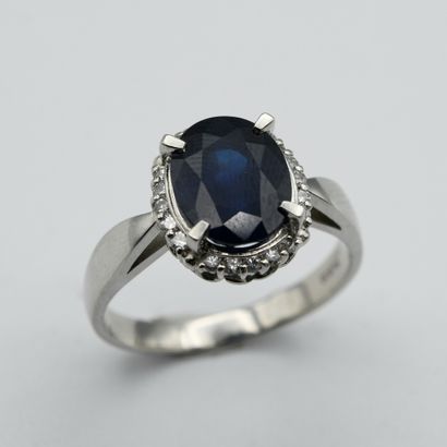 A pompadour ring centered with an oval sapphire...