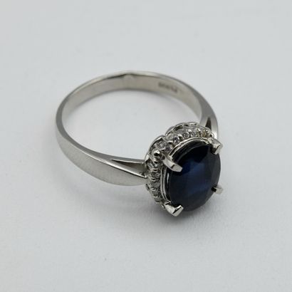 A pompadour ring centered with an oval sapphire...