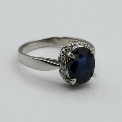 A pompadour ring centered with an oval sapphire...