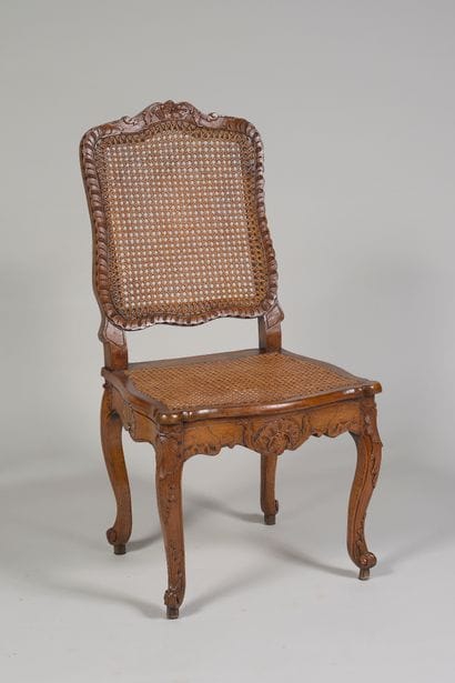 Chaise cannée 

en hêtre richement sculpté...