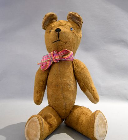 Ourson peluche portant un nœud à carreaux....