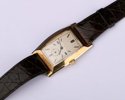 Montre en or jaune de forme tonneau. 
Cadran...