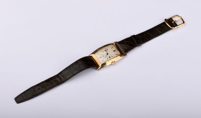 Montre en or jaune de forme tonneau. 
Cadran...