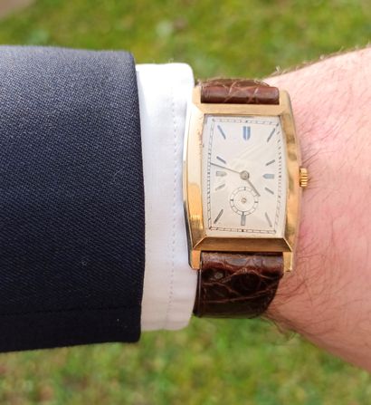 Montre en or jaune de forme tonneau. 
Cadran...