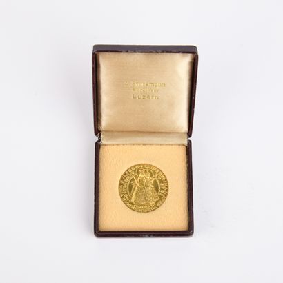 Yellow gold medal featuring the Virgin Mary...