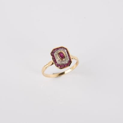 Modern ring centered on an oval ruby in a...