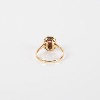 Modern ring centered on an oval ruby in a...