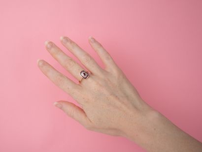 Modern ring centered on an oval ruby in a...