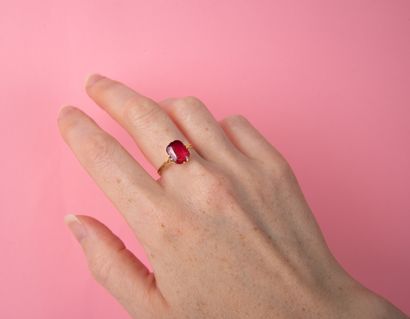 Antique ring centered with an imitation red...