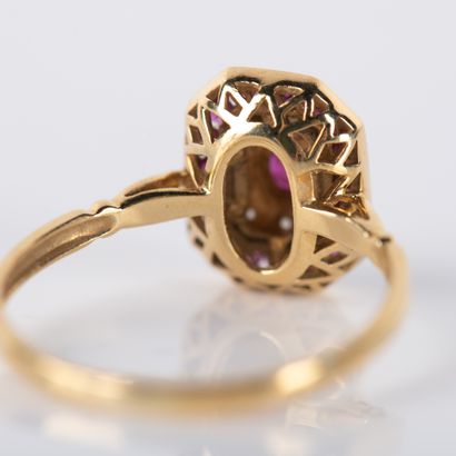Modern ring centered on an oval ruby in a...