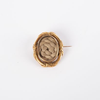 Oval-shaped reliquary brooch containing braided...