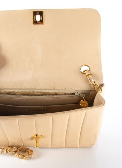 CHANEL
Beige lambskin bag with vertical stitching.
Flap...