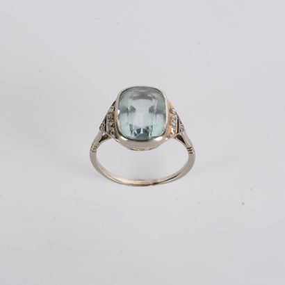 Ring centered on a cushion-cut aquamarine
in...