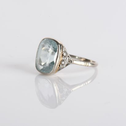 Ring centered on a cushion-cut aquamarine
in...
