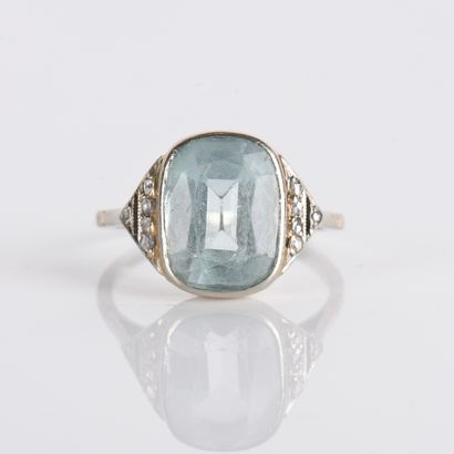 Ring centered on a cushion-cut aquamarine
in...