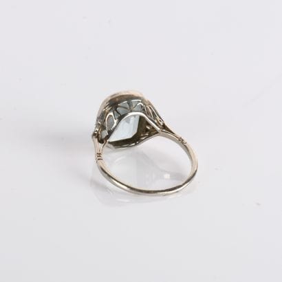 Ring centered on a cushion-cut aquamarine
in...
