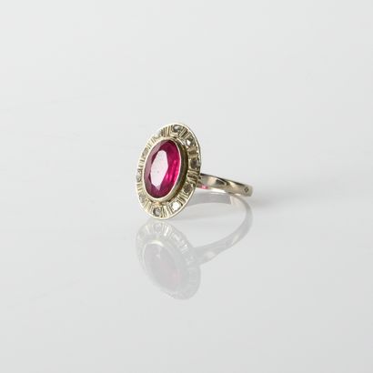 18K (750
oval bezel ring centered on a synthetic
ruby,...
