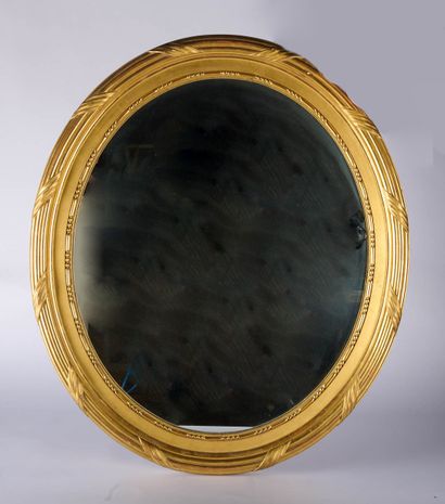 Miroir ovale en bois et stuc doré à décor...