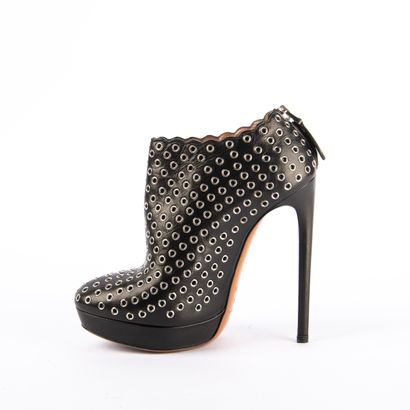 ALAÏA PARIS. Black leather heeled boots embellished...