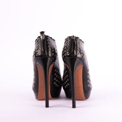 ALAÏA PARIS. Black leather heeled boots embellished...