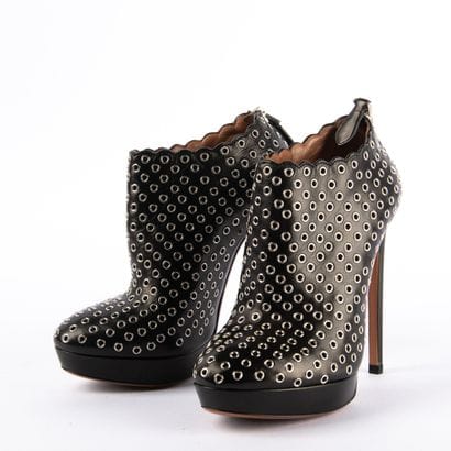 ALAÏA PARIS. Black leather heeled boots embellished...