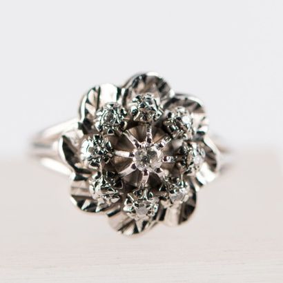 Bague fleur en or gris, ornée d'un diamant...