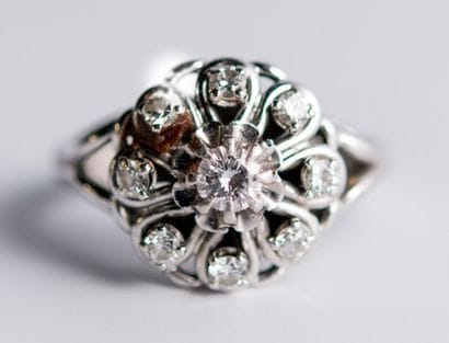 Bague fleur en or gris, ornée d'un diamant...