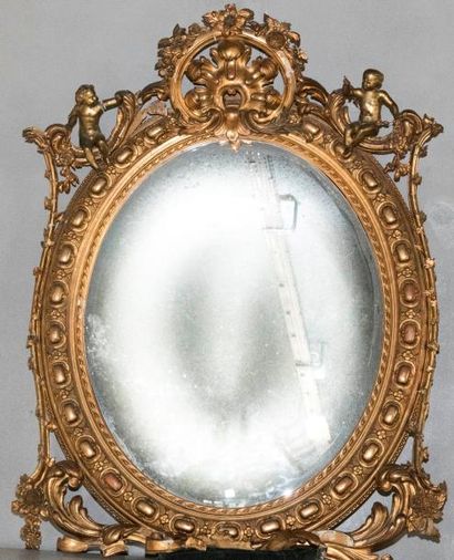 Miroir ovale en bois et stuc doré à décor...